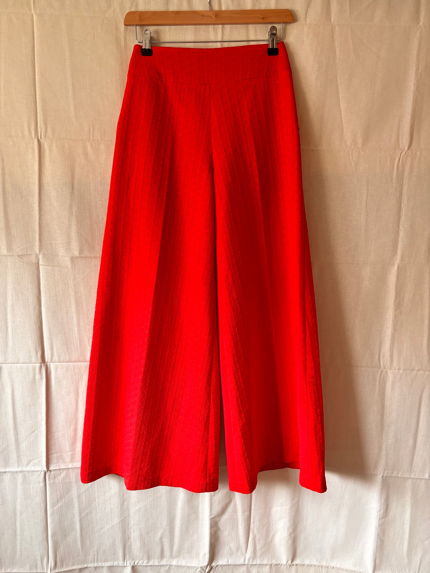 front view of 1960s/70s red textured high waisted flares