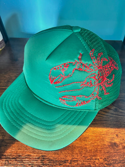 Green cap with red lobster hand-embroidered on the side. 