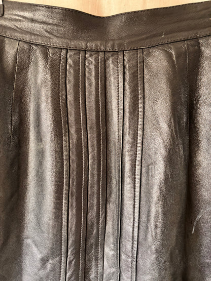 Close-up of pleated black leather skirt