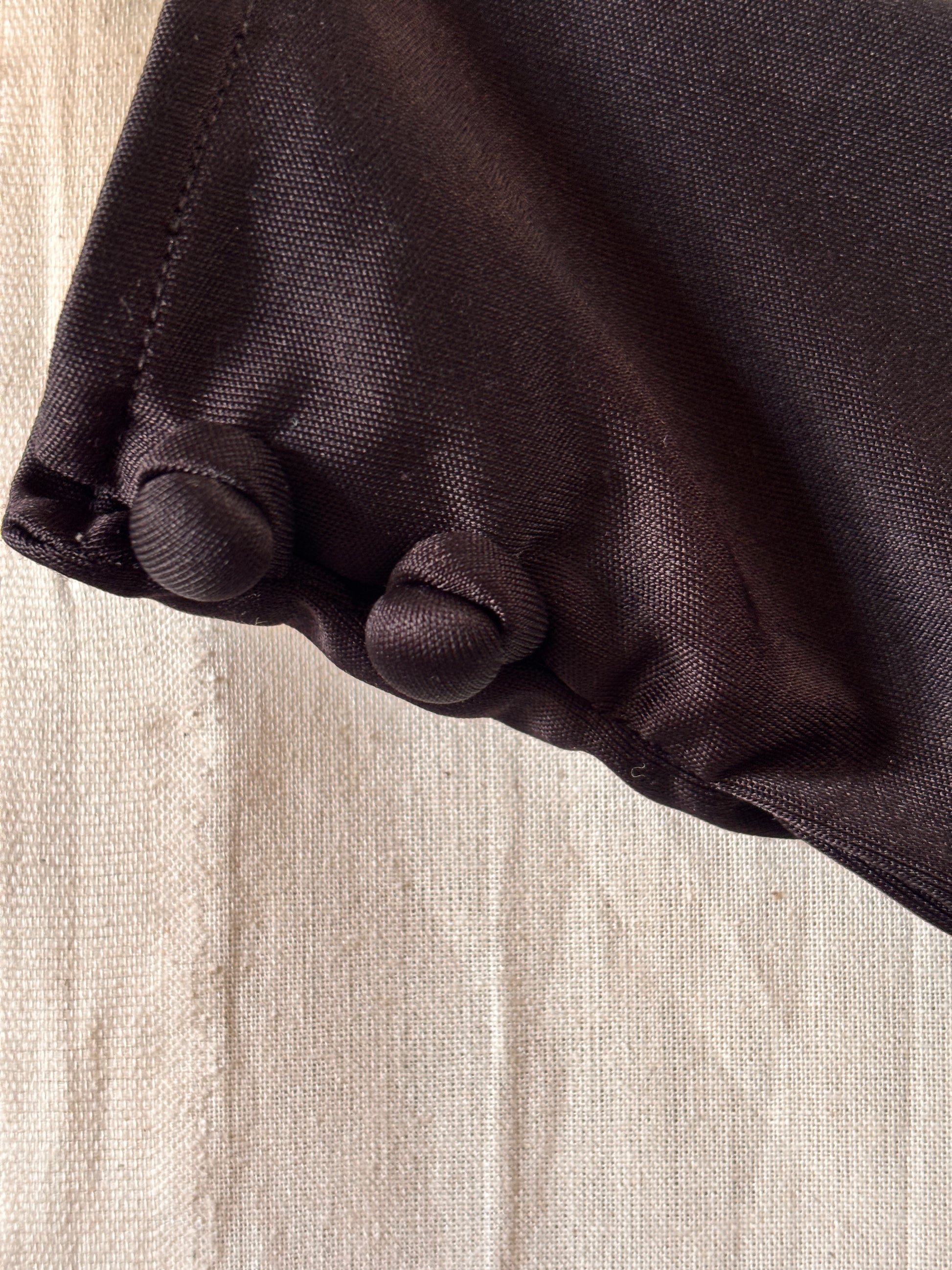 close up of buttons on cuffs of Yuki for Rembrandt black zip-front kaftan