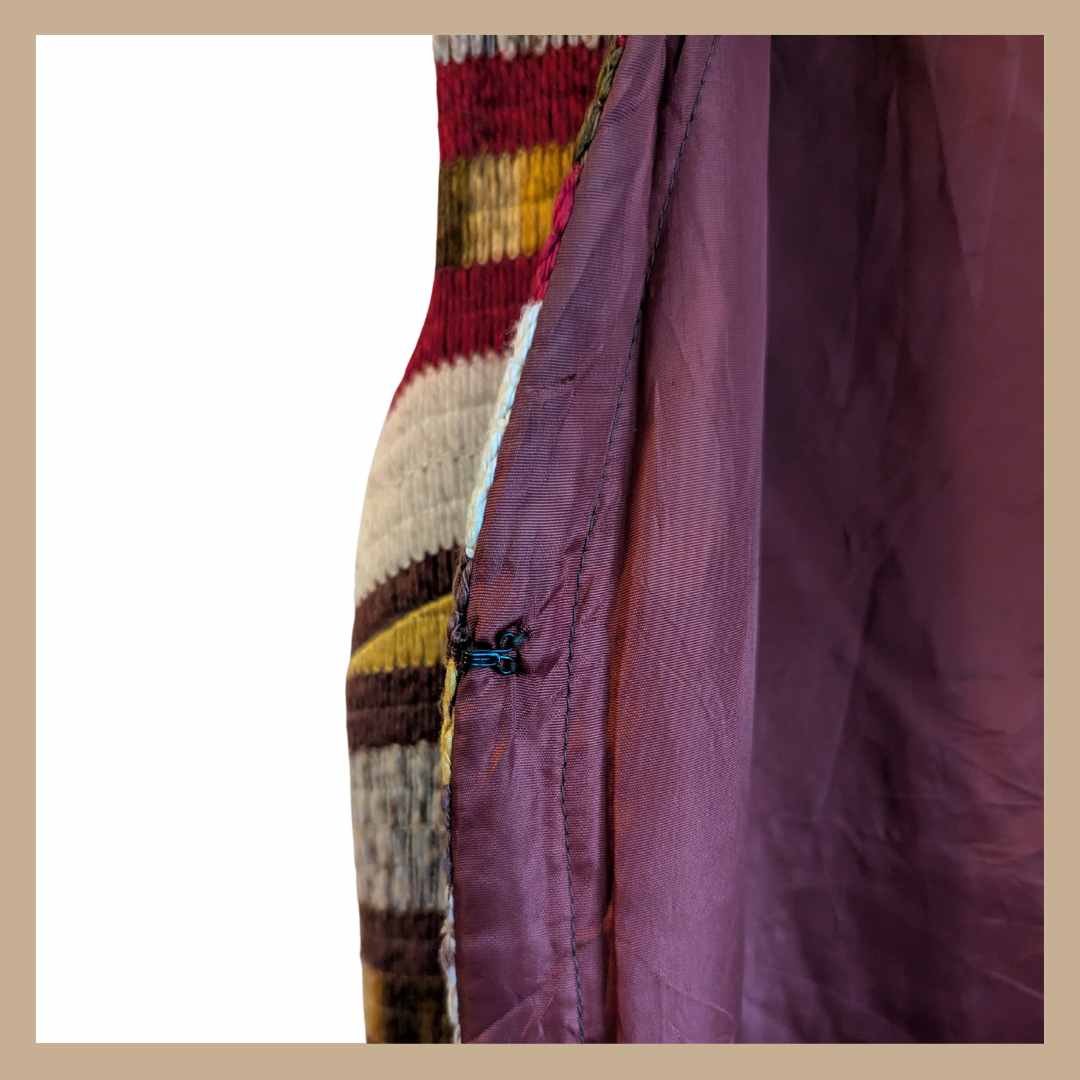 Hook and eye fastening of vintage 1970s sleeveless duster waistcoat